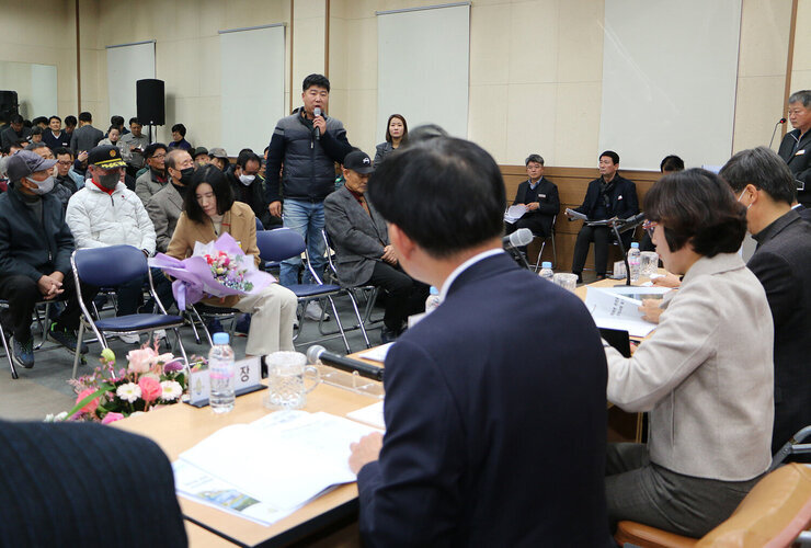 금천면 주민과의 대화 대화장 앞쪽의 절은 남성 주민이 자리에 서서 마이크를 잡고 질의를 하고 있는 모습과 대화석에 앉아서 듣고 있는 나주시장의 뒷모습
