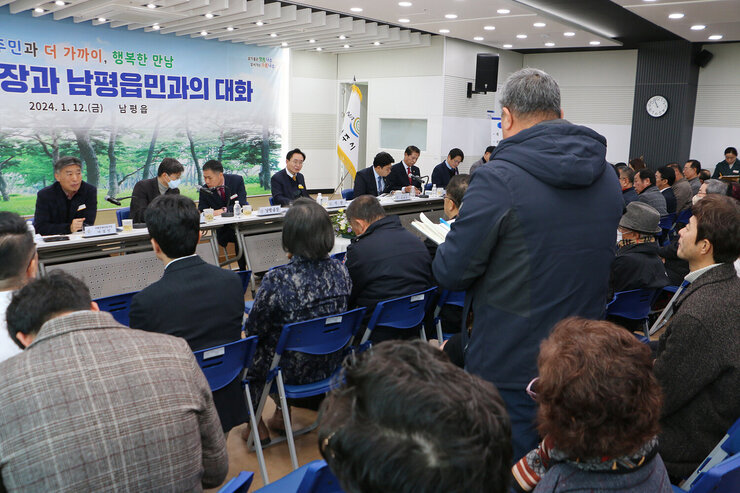 남평읍 주민과의 대화 남성 주민이 자리에 서서 질의를 하고 있는 모습과 나주시장이 듣고 있는 모습 왼촉 측면에서 촬영