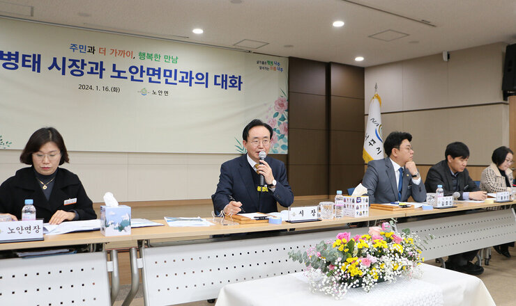 노안면 주민과의 대화  나주시장이 대화장으 대화석에서 마이크를 잡고 주민의 질의에 답변을 하고 있는 모습 양 옆으로 면장과 도의원 시의원이 보인다
