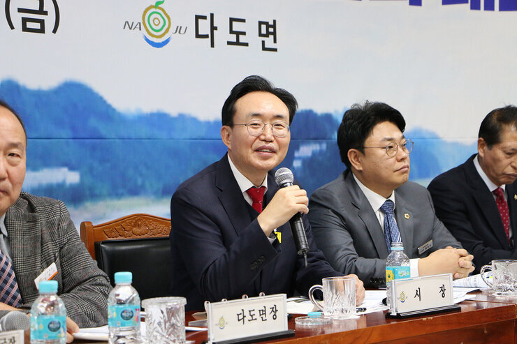 다도면 주민과의 대화 좌측에서 촬영한 대화석의 나주시장이 주민의 질의에 마이크를 들고 미소를 띄며 답변을 하는 모습