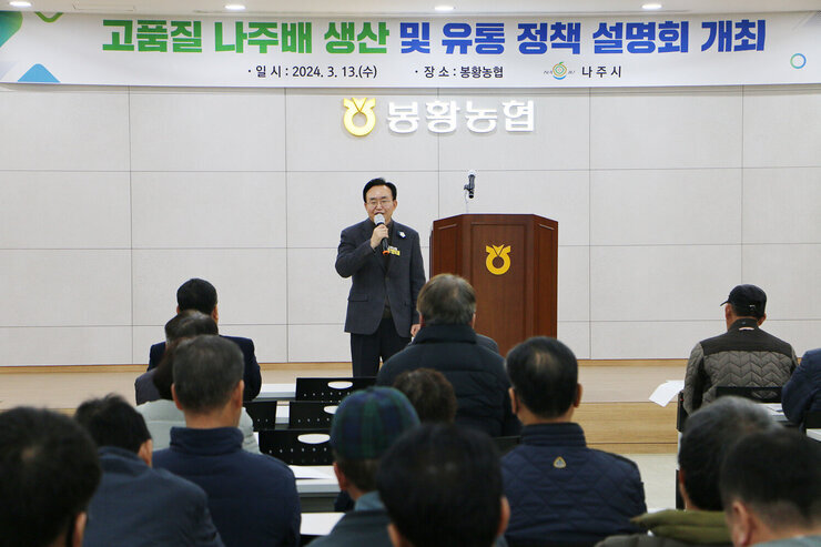 고품질 나주배 생산 및 유통정책 설명회 나주시장의 인사말 모습과 참석자들의 앉아 있는 뒷모습