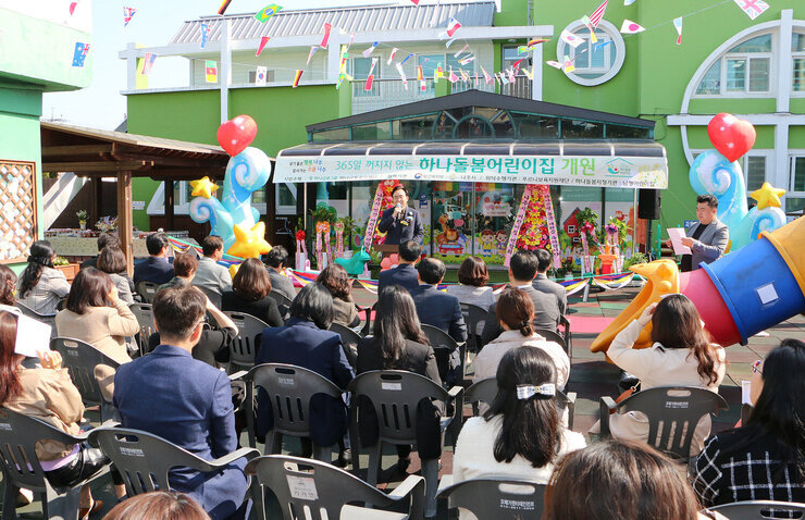 365일 하나돌봄 보육실 개원식 나주시장의 축사모습과 참석자들이 자리에 앉아 있는 뒷모습