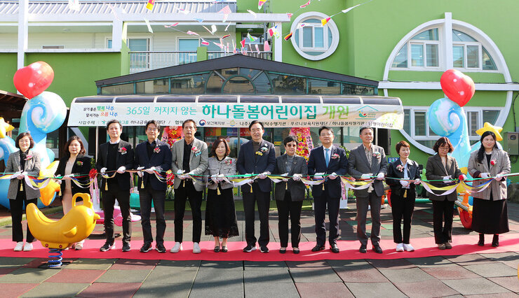 365일 하나돌봄 보육실 개원식 나주시장과 남평어린이집 원장, 시의원 및 하나그룹 관계자 등이 어린이집 앞에서 테이크 컷팅 전 기념촬영을 하고 있는 모습