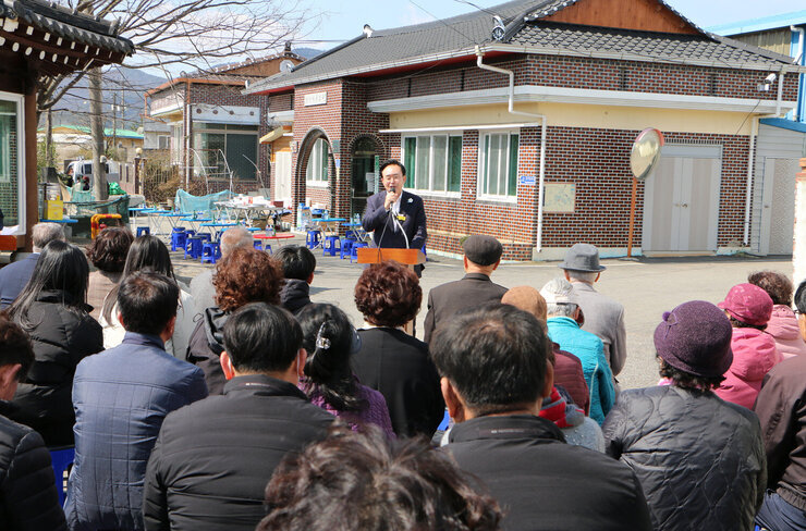 노안면 남산마을회관 준공식 측면에서 촬영한 나주시장의 인사말 모습과 참석한 마을분들의 앉아 있는 모습