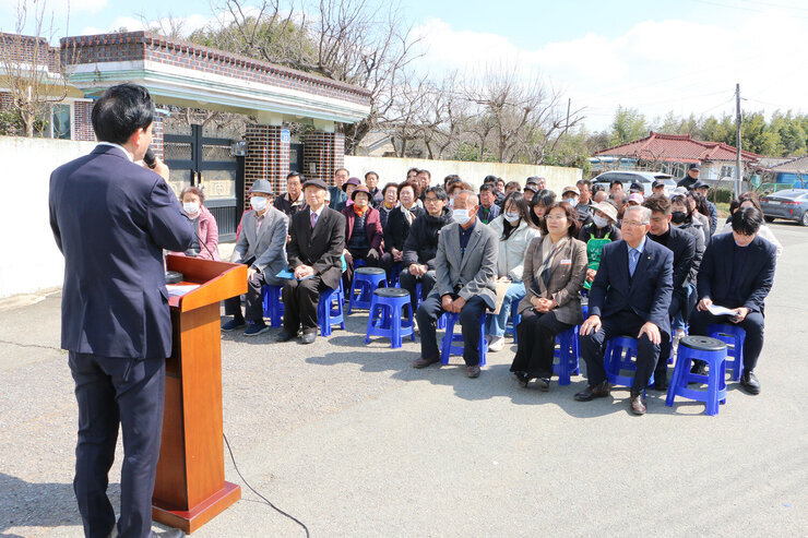 노안면 남산마을회관 준공식 축사를 하고 있는 나주시장의 뒷편에서 촬영한 모습 참석 마을 분들의 앉아 있는 앞모습이 보인다