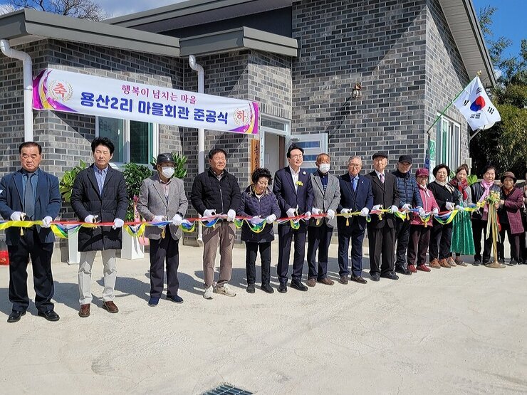 노안면 남산마을회관 준공식 나주시장과 마을 주민 및 관계자들이 신축 마을회관 앞에서 테이프 컷팅식 전 기념촬영을 하고 있는 모습