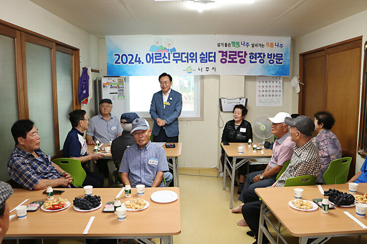 무더위 쉼터 현장 점검 나주시장이 경로당 입식테이블 앞에 서서 어르신들께 인사말을 하고 잇는 모습과 듣고 잇는 어르신들의 모습