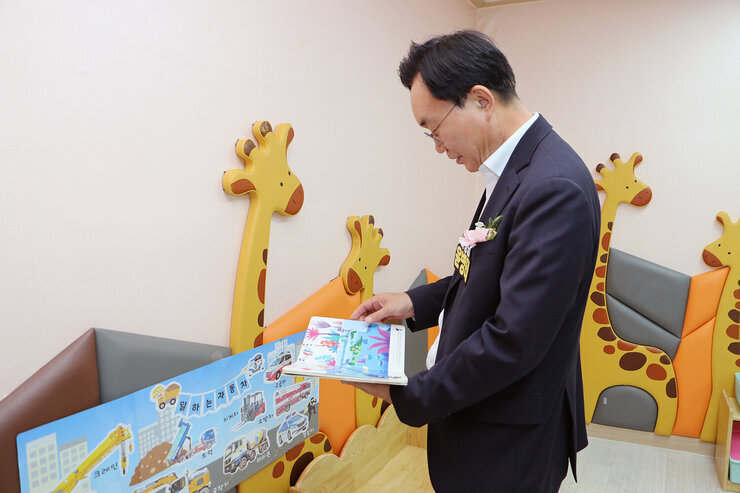 나주시 365일 시간제 보육실 개원식 나주시장이 보육실 내부에 마련된 그림첵을 살펴보고 있는 모습