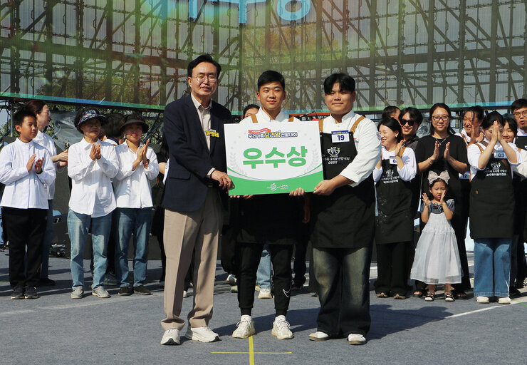 영산강축제 우리가족 요리왕 선발대회 주무대 위에서 나주시장이 우수상을 받은 팀과 기념촬영을 하고 있는 모습