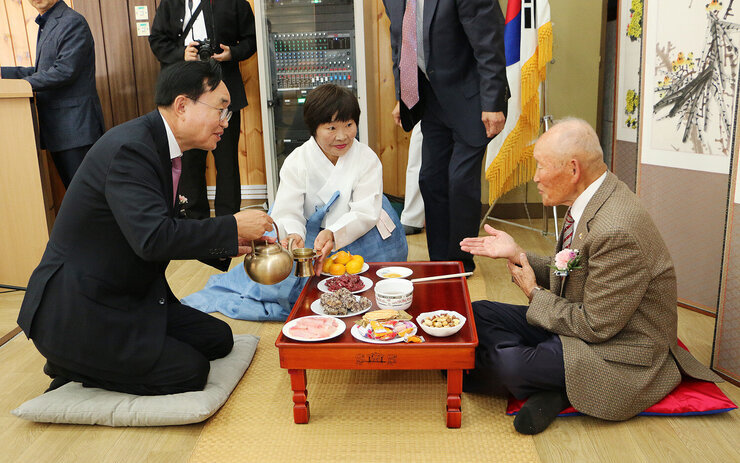 나주향교 기로연 나주시장이 장수어르신께 헌수를 위해 주전자의 술을 따르고 있는 모습 상을 중심으로 어르신과 마주앉아 있다