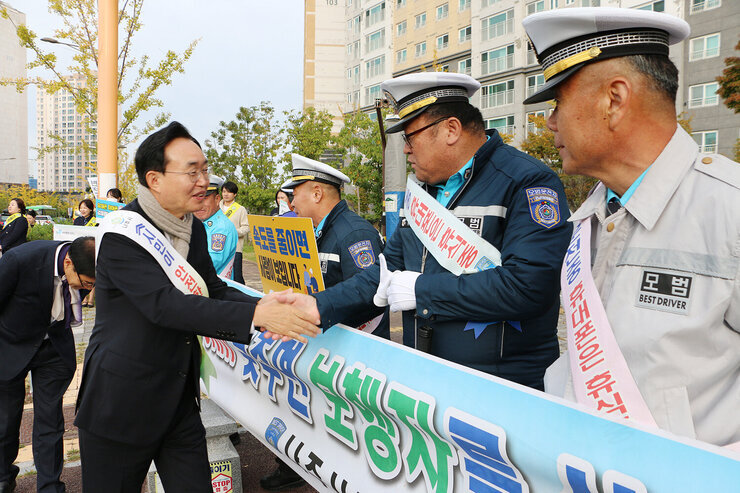초등학교 등굣길 교통안전 캠페인 나주시장이 모범운전자회 회원과 악수를 나누고 있는 모습