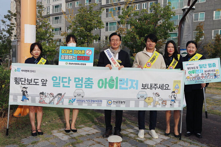 초등학교 등굣길 교통안전 캠페인 나주시장과 녹색어머니연합회 회원 5명과 프래카드를 펼치고 기념촬영을 하고 있는 모습
