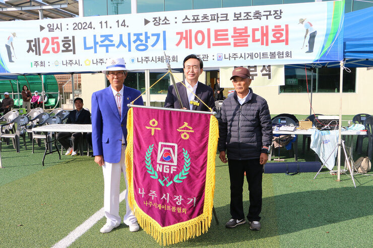 제25회 나주시장기 게이트볼대회 나주시장과 전년 우승팀의 대표자가 우승기를 들고 기념촬영을 하고 있는 모습