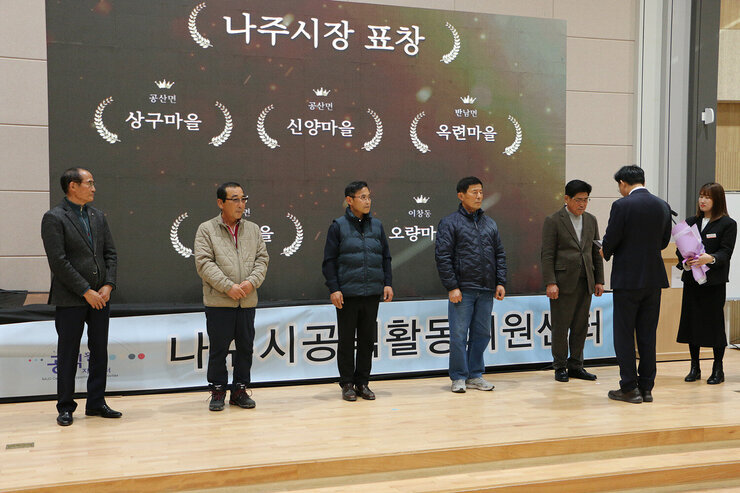 청정전남 으뜸마을 만들기 성과 공유회 나주시장이 각 마을 대표 4명에게 시상을 하고 있는 모습