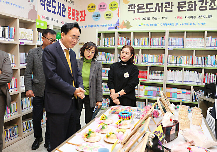 LH5단지 프로그램 성과나눔 전시회 나주시장이  테이블에 전시된 작품들을 바라보고 있는 모습