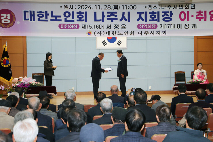 대한노인회 나주시지회 회장 이취임식 이임하는 노인회장이 취임하는 노인회장에게 감사장을 전달하고 있는 모습