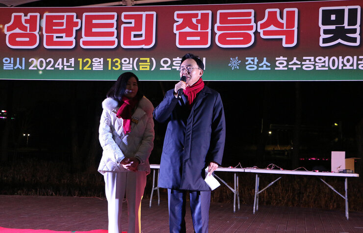 성탄트리 점등식 나주시장이 무대 위에서 인사말을 하고 있는 묘습 옆에 배우자가 함께 서 있는 모습