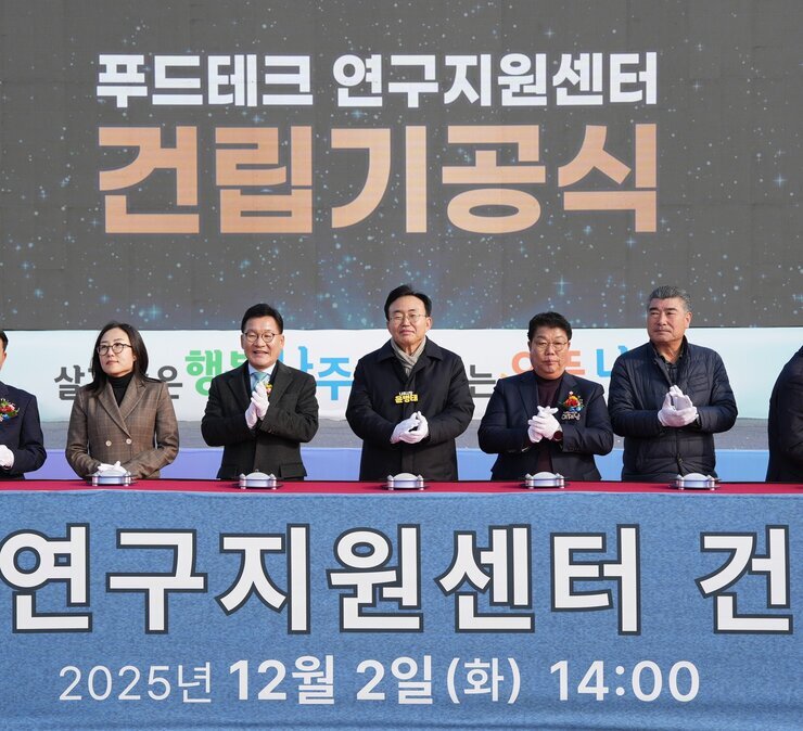  푸드테크 연구지원센터 건립기공식 커팅식 참석자 클로즈업. 다섯 명(중앙 나주시장 윤병태)의 주요 참석자들이 흰색 장갑을 끼고 준비하고 있는 모습이다. 배경에는 '푸드테크 연구지원센터 건립기공식'이라는 글자가 크게 보인다.