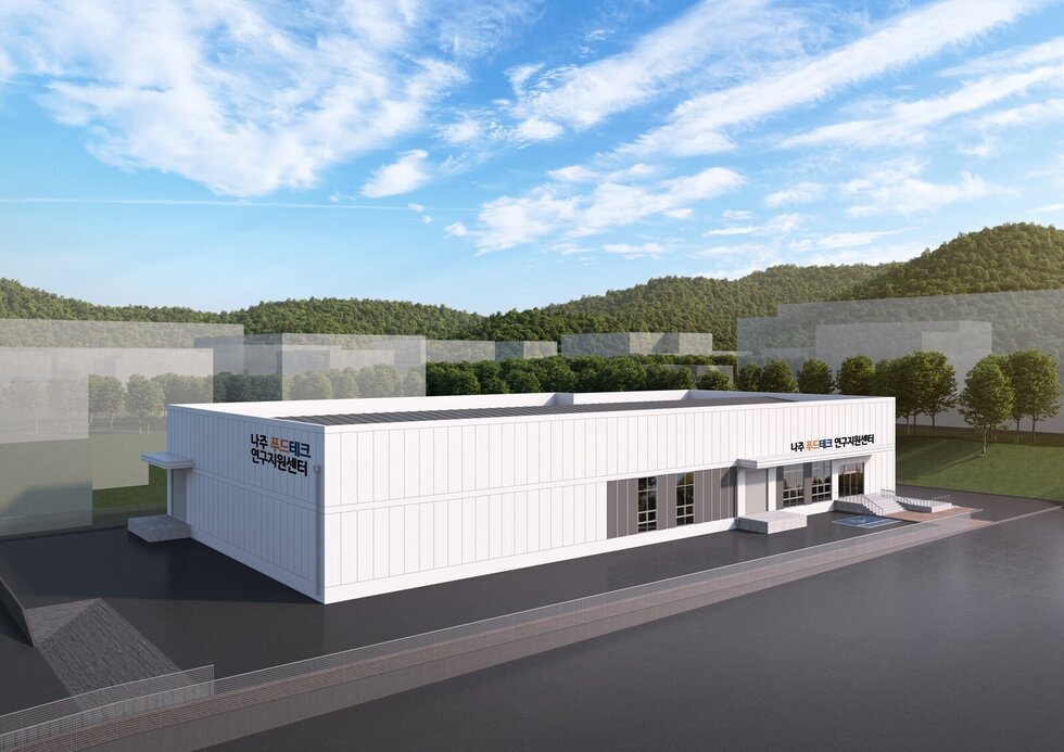 맑은 하늘 아래 신축 건물 조감도. 건물의 외벽에는 '나주 푸드테크 연구지원센터' 라는 글자가 적혀 있다.