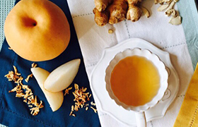 찻잔에 담긴 배즙과 배가 찻상에 놓여진 모습