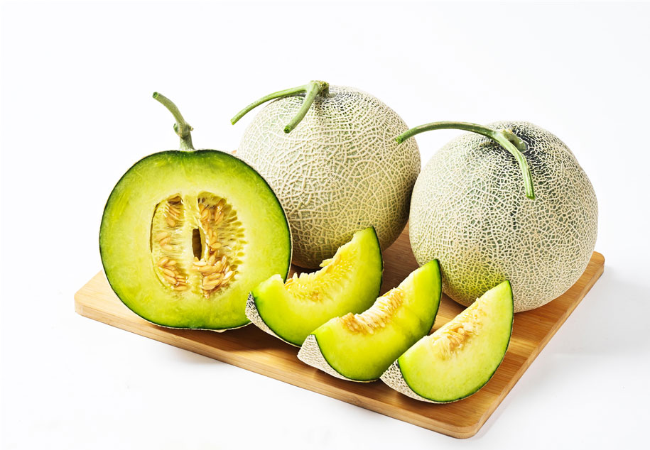 썰어져있는 멜론과 함께 멜론들이 도마위에 놓여있는 모습