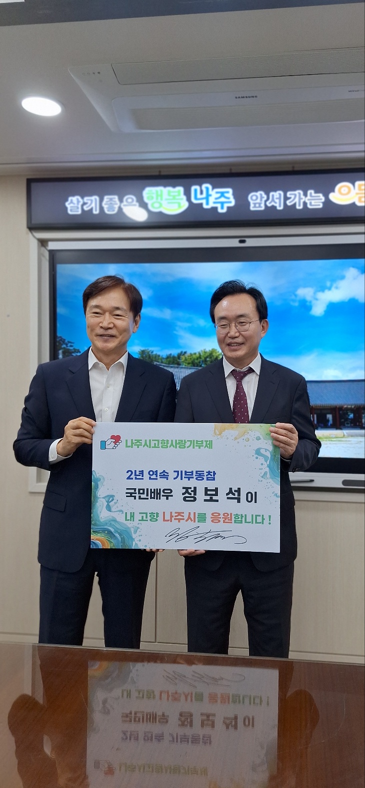 나주시고향사랑기부제 2년 연속 기부동참 국민배우 정보석이 내 고향 나주시를 응원합니다! 라는 팻말을 들고 있는 배우 정보석과 윤병태 시장