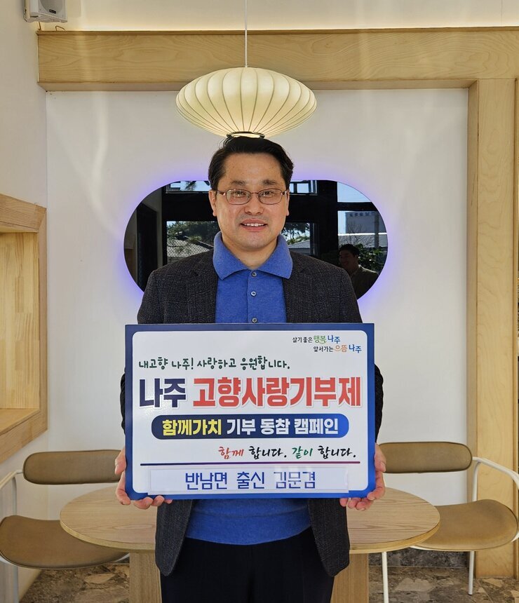  살기좋은 행복 나주 앞서가는 으뜸 나주 내고향 나주! 사랑하고 응원합니다. 나주시 고향사랑 기부 금 5,000,000원 함께 합니다. 같이 합니다.  반남면 출신 김문겸 이라고 적힌 팻말을 들고 있는 김문겸