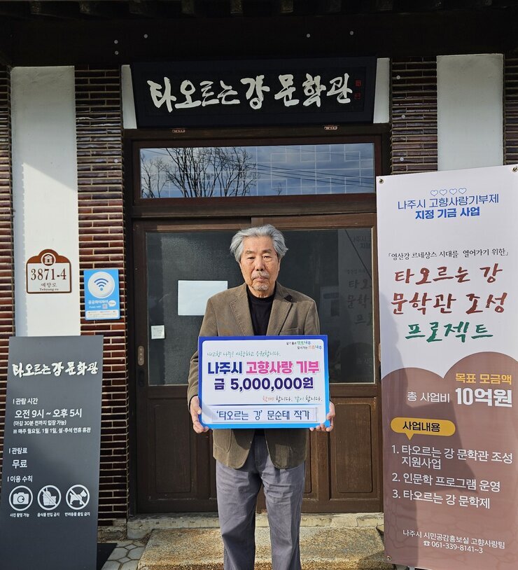  타오르는 강 문학관 3872-4 예향로 타오르는 강 문학관 |관람시간 오전 9시~오후5시(마감 30분 전까지 입장 가능) ※매주 월요일, 1월1일, 설,추석 연휴 휴관 |관람료 무료 |이용수칙 사진촬영가능 음식물 반입 금지 반려동물 출입 금지 라고 적힌 안내판. 나주시 고향사랑기부제 지정 지금 사업 「영산강 르네상스 시대를 열어가기 위한」타오르는 강 문학관 조성 프로젝트 목표 모금액 총 사업비 10억원 사업내용 1.타오르는 강 문학관 조성 지원사업 2.인문학 프로그램 운영 3.타오르는 강 문학제 나주시 시민공감홍보실 고향사랑팀 061-339-8141~3 현수막.  살기좋은 행복 나주 앞서가는 으뜸 나주 내고향 나주! 사랑하고 응원합니다. 나주시 고향사랑 기부 금 5,000,000원 함께 합니다. 같이 합니다.  '타오르는 강' 문순태 작가 라고 적힘 팻말을 들고 있는 문순태 작가
