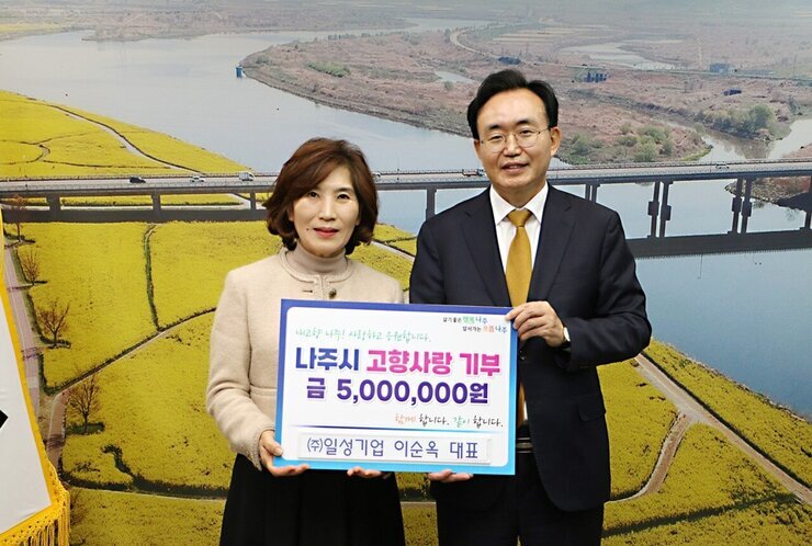 살기좋은 행복 나주 앞서가는 으뜸 나주 내고향 나주! 사랑하고 응원합니다. 나주시 고향사랑 기부 금 5,000,000원 함께 합니다. 같이 합니다. (주)일성기업 이순옥 대표 라고 적힌 팻말을 들고 사진을 찍고 있는 이순옥 대표와 윤병태 시장