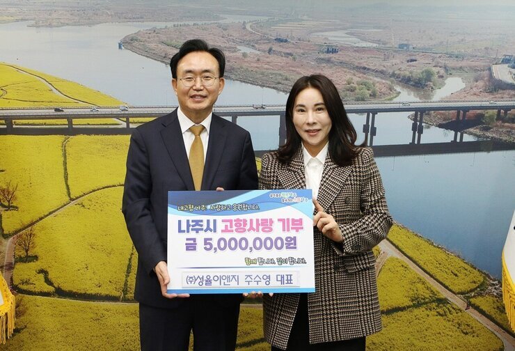 살기좋은 행복 나주 앞서가는 으뜸 나주 내고향 나주! 사랑하고 응원합니다. 나주시 고향사랑 기부 금 5,000,000원 함께 합니다. 같이 합니다. (주)성율이앤지 주수영 대표 라고 적힌 팻말을 들고 사진을 찍고 있는 윤병태 시장과 주수영 대표