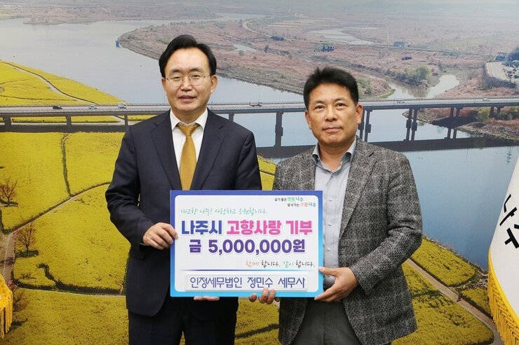  살기좋은 행복 나주 앞서가는 으뜸 나주 내고향 나주! 사랑하고 응원합니다. 나주시 고향사랑 기부 금 5,000,000원 함께 합니다. 같이 합니다. 인정세무법인 정민수 세무사  라고 적힌 팻말을 들고 사진을 찍고 있는 윤병태 시장과 정민수 세무사