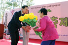 나주시 노인복지관 문화대축제 무대 위에서 나주시장이 여성 어르신에게 풍선 꽃다발을 전달 받고 있는 모습