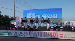2025년 우습제 음악회 스크린 앞에서 홍련꽃잎이 흐르는 선율 2025년 우습제 음악회 주최 나주시 주관 공산면 현수막이 걸린 무대위에서 메아리 하모니카 동아리 거치대 옆에서 퍼포먼스중인 참여자들