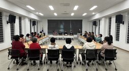 테이블에 앉아 박수치고있는 위원회원들 모습