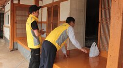 마루에 반찬을 놓으며 방안의 주민과 대화중인 봉사자들