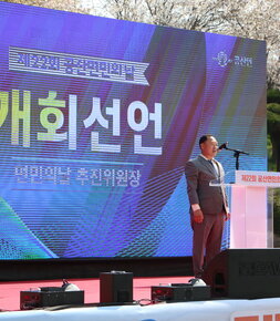 제22회 공산면민의날 개회선언 면민의날 추진위원장 스크린앞에서 제22회 공산면민의 날이 적힌 단상에서 발표하는 발표자