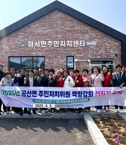 마서면주민자치센터 앞에서 2025년 공산면 주민자치위원 역량강화 선진지 견학 국립생태원 / 마서면주민자치센터 2025.4.3 / 공산면 주민자치위원회 현수막 뒤에 화이팅 포즈로 서있는 위원회원들