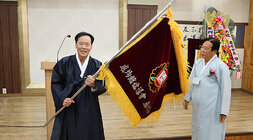 나주향교 전교, 성균관 유도회장 이.취임식 이임하는 유도회장 분이 취임하는 유도회장 분에게 관련 기를 전달하고 있는 모습