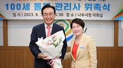 100세 돌봄 관리사 위촉식 돌봄관리사 대표자 분이 나주시장에게 꽃다발 전달 후 함께 기념촬영 모습 