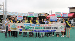 추석맞이 전통시장 및 상점가 이용 홍보 캠페인 나주시장과 시청 직원들이 홍보 플래카드를 펼치고 기념촬영을 하고 있는 모습