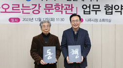 타오르는 강 문학관 업무 협약식 나주시장과 문순태 작가가 각각 협약서 겉면에 동행이라는 글씨가 새겨져 있는 협약서를 들고 기념촬영을 하고 잇는 모습