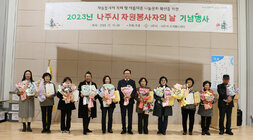 2023년 자원봉사자의 날 기념행사 나주시장과 시상을 받은 10명이 표창장과 꽃다발을 들고 기념촬영을 하고 있는 모습