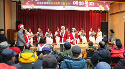 나주시 노인복지관 메리 동지 행사 나주시장이 인사말을 하고 있고 옆에 배우자가 서 있고 참석자들의 뒷모습이 보이는 모습