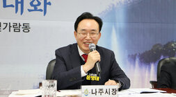 빛가람동 주민과의 대화 나줏지ㅏㅇ이 미소를 띄며 주민의 질의를 듣고 있는 모습과 양 옆으로 동장과 도의원 모습이 보인다