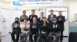 나주시 이동노동자 쉼터 개소식 나주시장과 이동노동자, 도의원 2명 시의원 등이 현판 앞에서 바수를 치며 기념촬영을 하고 있는 모습