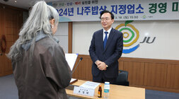 나주밥상 지정업소 경영마인드 교육 지정업소 대표자 여성 한명이 실천 다짐 선언문을 낭독하고 나주시장이 함께 서서 낭독을 듣고 있는 모습