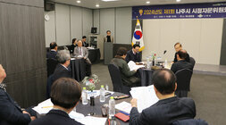 나주시 시정자문위원회 위원 중 한분이 사회자 연단에서 시정에 대한 건의를 발표하고 있는 모습과 원형테이블의 위원들의 못흡