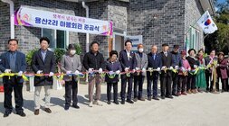 노안면 남산마을회관 준공식 나주시장과 마을 주민 및 관계자들이 신축 마을회관 앞에서 테이프 컷팅식 전 기념촬영을 하고 있는 모습