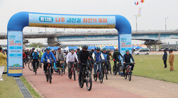 나주 영산강 자전거 대회 자전거 대회 참여자들이 에어 풍선 앞에서 스타트를 하고 있는 모습