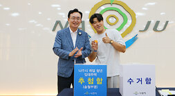 나주시 취업청년 임대주택 동, 호수 추첨 및 입주 설명회나주시장과 동, 호수 추첨을 완료한 남성 청년이 기념촬영을 하고 있는 모습